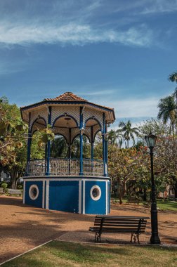 Eski renkli gazebo ve aydınlatma direği Bahçe dolu yemyeşil ağaçlarda Sao Manuel, güneşli bir gün ortasında. Sao Paulo eyalet kırsal kesimde şirin bir kasaba. Güneydoğu Brezilya.