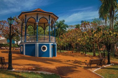 Eski renkli gazebo ve aydınlatma direği ortasında yemyeşil bahçede Sao Manuel, güneşli bir gün. Sao Paulo eyalet kırsal kesimde şirin bir kasaba. Güneydoğu Brezilya. Düzeltisiz fotoğraf