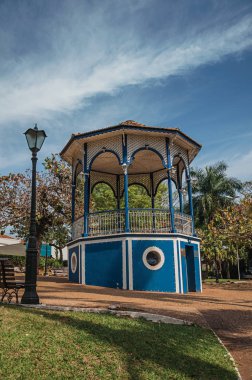 Eski renkli gazebo ve aydınlatma direği ile Sao Manuel, güneşli bir günde yeşil çim Bahçe ortasında. Sao Paulo eyalet kırsal kesimde şirin bir kasaba. Güneydoğu Brezilya.