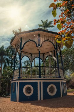 Ağaçlar ve güneş Sao Manuel, yemyeşil bahçe tam ortasında eski renkli çardak close-up. Sao Paulo eyalet kırsal kesimde şirin bir kasaba. Güneydoğu Brezilya. Düzeltisiz fotoğraf.