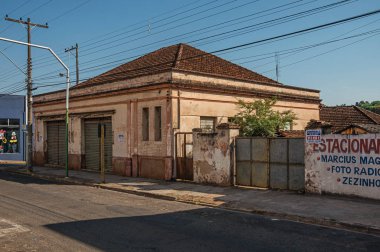 Sao Manuel, Güneydoğu Brezilya - 14 Ekim 2017. Outworn eski ev ve duvar boyalı Sao Manuel günbatımında boş sokakta afişinde ile. Sao Paulo eyalet kırsal kesimde şirin küçük bir kasaba