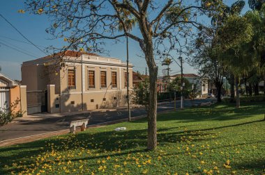 Eski süslü townhouse San Manuel, güneşli bir günde herdem yeşil bahçesinde ağaçlar ile boş bir sokakta. Sao Paulo eyalet kırsal kesimde şirin bir kasaba. Güneydoğu Brezilya.