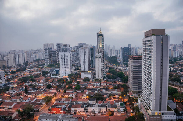 View of the city skyline in the early morning light with houses and buildings under cloudy skies in the city of Sao Paulo. The gigantic city, famous for its cultural and business vocation.