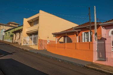 Sao Manuel, southeast Brazil - October 14, 2017. Working-class colored houses and fences in an empty street on a sunny day at San Manuel. A cute little town in the countryside of Sao Paulo State. clipart