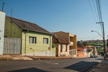 Sao Manuel, Güneydoğu Brezilya - 14 Ekim 2017. Sao Manuel, güneşli bir yokuş aşağı cadde görünümü kaldırım duvarlı ve renkli ev sahipliği yapmaktadır. Sao Paulo eyalet kırsal kesimde şirin küçük bir kasaba.