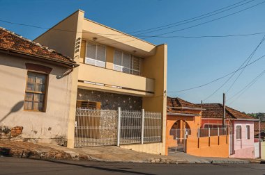 Sao Manuel, southeast Brazil - October 14, 2017. Working-class colored houses and fences in an empty street on a sunny day at San Manuel. A cute little town in the countryside of Sao Paulo State. clipart