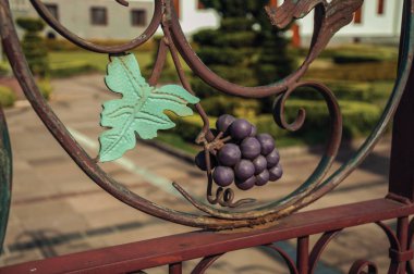 Decorative grape and vine leaves on iron gate clipart