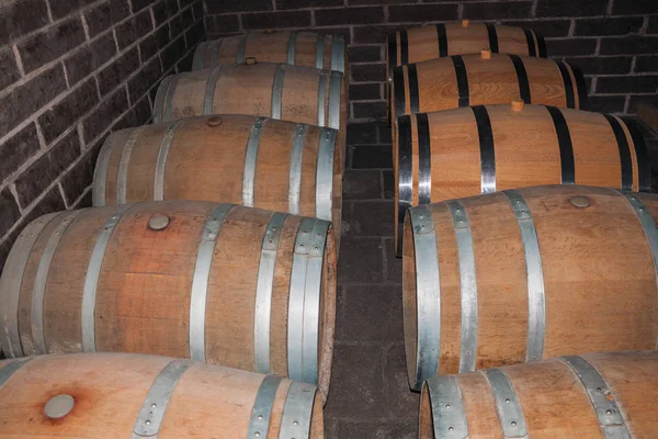 Barils en bois pour le stockage du vin dans une cave — Photo