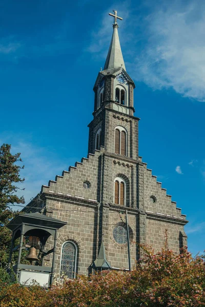 Kostelní fasáda s věží a zahradou v Gramadu — Stock fotografie