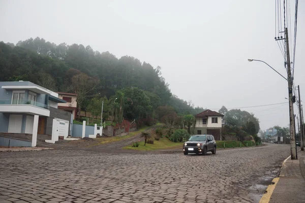 Rua de pedra com casas e carros em um dia nebuloso — Fotografia de Stock