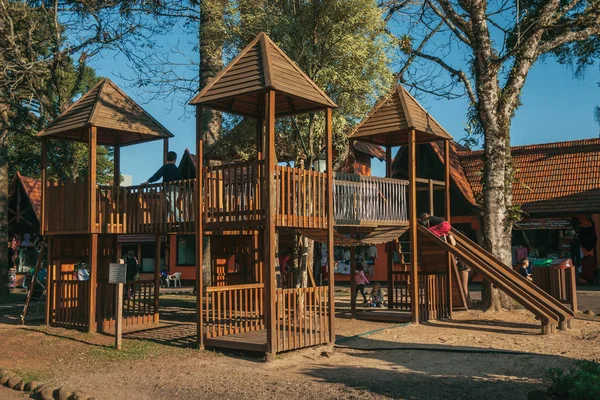 Playground equipment among trees with children — Stock Photo, Image