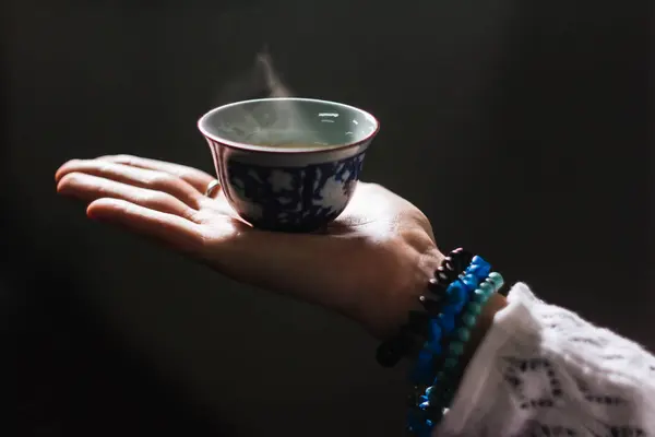 Chinese tea cup with hot green tea in beautiful women hand — Stock Photo, Image