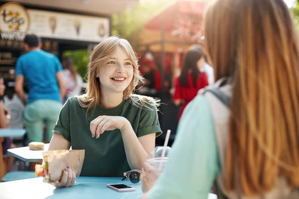Teman terbaik yang mengobrol di hari yang cerah makan taco di taman atau faire, tersenyum gembira, membahas masa depan mereka makanan sehat startup . — Stok Foto