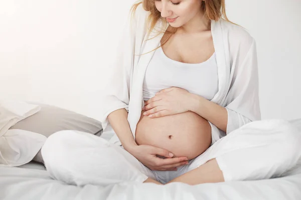 A gravidez é um presente. Mulher grávida em antecipação de seu menino, relaxando em seu quarto na cama . — Fotografia de Stock