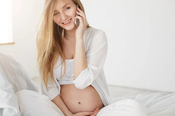 Mulher grávida falando ao telefone, olhando feliz anticipaiting sua maternidade esperando um bebê — Fotografia de Stock