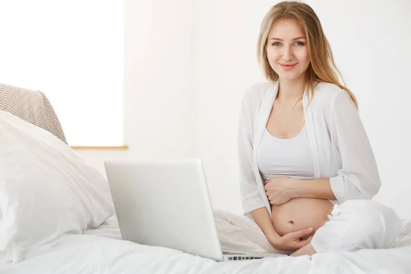 Mulher grávida usando laptop em casa. Empreendedor on-line executando sua loja online de vestuário para crianças — Fotografia de Stock