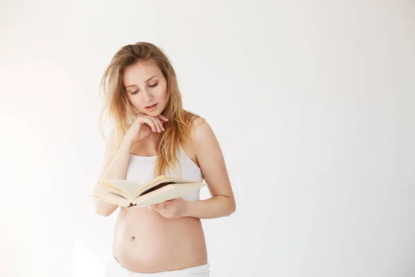 Donna incinta che legge un libro fingendo di essere una modella o una beauty blogger — Foto Stock