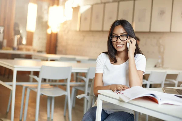 Studente che parla al telefono prendendo una pausa dalle lezioni o lezioni in biblioteca openspace chatta con i suoi amici — Foto Stock