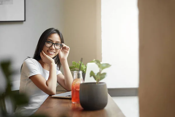 Startup asiática diseñador chica trabajando en portátil en su nuevo proyecto sentado en la cafetería o coworking o un hub . — Foto de Stock