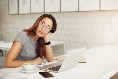 Başarılı online mağaza geniş studio veya kafe gözlüklü dizüstü kullanarak çalışan kadın girişimci. Serbest kavramı.