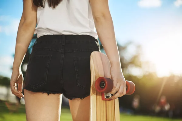 Bayan kaykaycı onun longboard tutan parkta eğleniyor, yakın çekim. — Stok fotoğraf