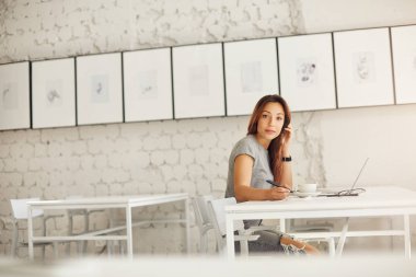 Grafik tasarımcı çizim kafe veya coworking veya kampüs, dizüstü kullanarak işyerinde kameraya arıyorum. Serbest iş kavramı.