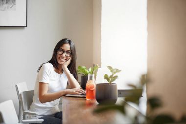 Genç ve akıllı girişimci limonata içmek ve kar keyfini yakın kafeden onun online iş çalışan.