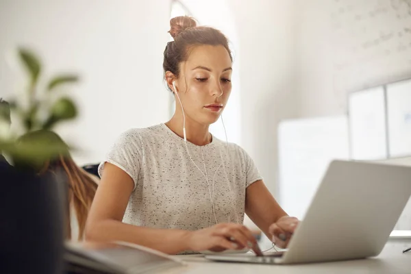 Jonge muziekproducent met behulp van een laptop voor het opstellen van een vrolijke hit. Freelance redacteur doorbladeren tonnen tekst te vinden van het perfecte scenario. — Stockfoto