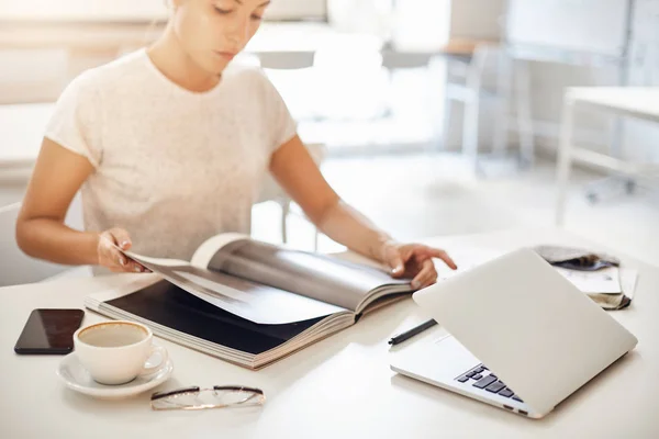 Procesul de design de moda. Femeia care lucrează la laptop și skimming printr-o revistă de catalog la modă pentru a lupta împotriva blocului creativ după o supradoză de cofeină — Fotografie, imagine de stoc