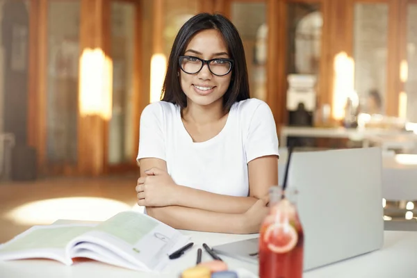 Retrato de mujer asiática sonriendo trabajando en el portátil en la cafetería o espacio de coworking brillante con gafas . —  Fotos de Stock