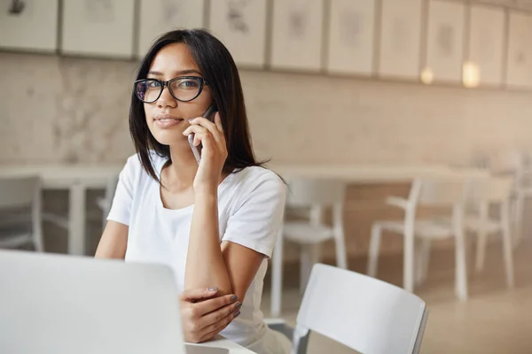 Jonge Oost-vrouw praten op mobiele telefoon camera bril kijken. — Stockfoto