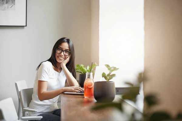 Joven e inteligente emprendedora que dirige su negocio en línea desde la cafetería cercana bebiendo limonada y disfrutando de los beneficios . — Foto de Stock