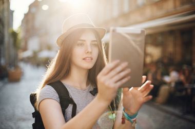 Bir tablet için ilginç yerler aramak ya da kendi yolunu bulmak için kullanma ya da sadece video aracılığıyla arkadaşlarınızla sohbet kadın turist. Seyahat kavramı.