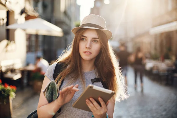 Touristin verloren in einer kleinen europäischen Stadt auf der Suche nach einer Wegbeschreibung in ihrem Tablet, in der Hand eine Karte. Reisekonzept. — Stockfoto