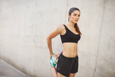 Mükemmel vücut şekli için yolda germe kadın çalışan atlet. Kentsel spor kavramı.
