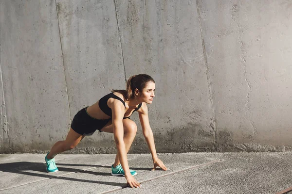 Atleta femenina lista para empezar a correr en la jungla de hormigón. Concepto de deporte urbano . — Foto de Stock