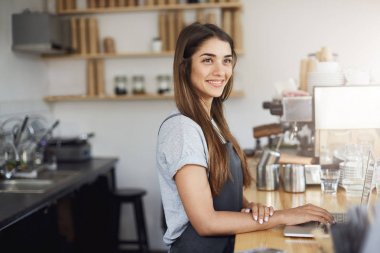 Genç kadın barista onun iş yeri arıyorum, bir dizüstü bilgisayar üzerinde çalışan gülümseyen mutlu