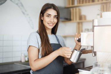 Bayan barista sütte kamera gülen arıyorum bir sürahi kaymağını deneyimli