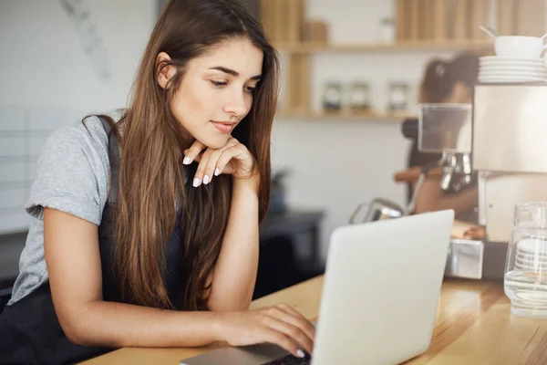 Studente donna che ha un lavoro estivo come barista nella caffetteria locale . — Foto Stock