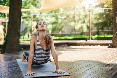 Genç kadın yogi Urdhva Mukha pratik yoga bir kentsel ortamda veya pilates egzersiz pratik Svanasana yapıyor.