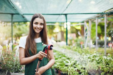 Mutlu genç kadın bahçıvan sulama tesisleri sahibi işletilen sera mağaza.