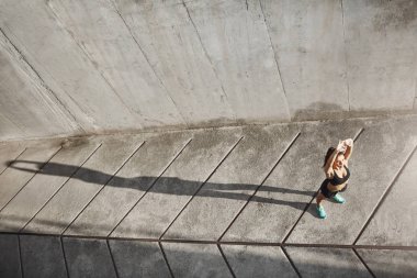 Kadın Runner geleceğe aydınlık ve güneşli bir dürtmek almaya uzanan geniş atış. Kentsel spor kavramı.