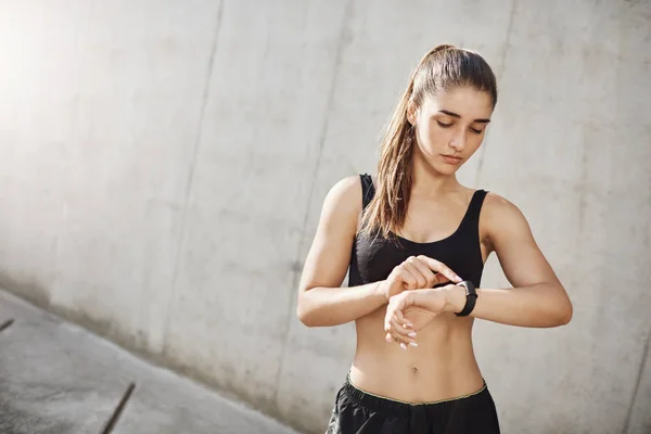 Giovane donna corridore utilizzando un fitness tracker per conoscere il suo cuore trato. Scienza al servizio dello sport . — Foto Stock
