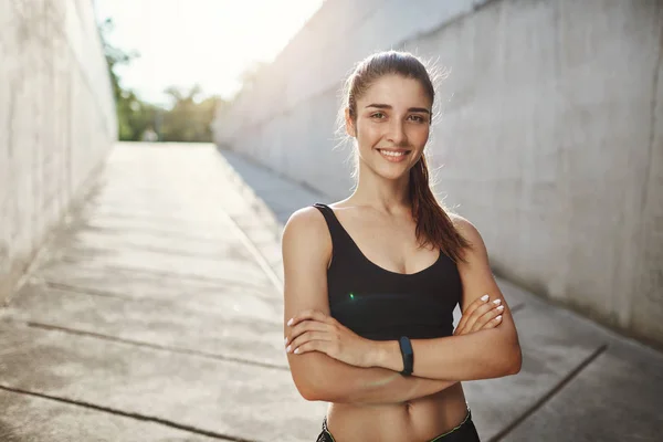 Retrato de mujer joven entusiasta de los deportes de pie confiado listo para el entrenamiento habitual de la ciudad. Mantenerse en forma en el entorno urbano . — Foto de Stock