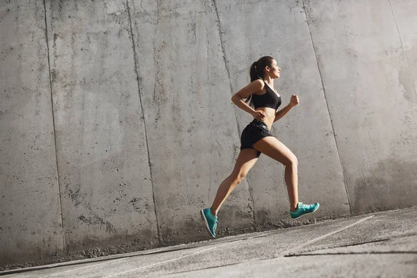 นักวิ่งกีฬาหญิงมุ่งมั่นในอนาคตที่สดใส ร่างกายที่เหมาะสมต้องทํางานอย่างหนัก แนวคิดกีฬาในเมือง . ภาพสต็อก