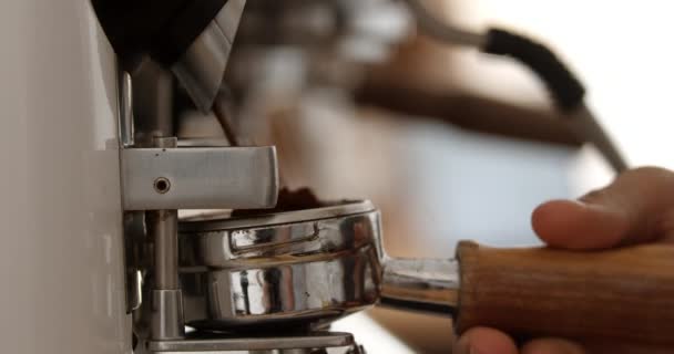 Close up van barista koffie slijpen in portafilter. Drukke café. Slow motion. — Stockvideo