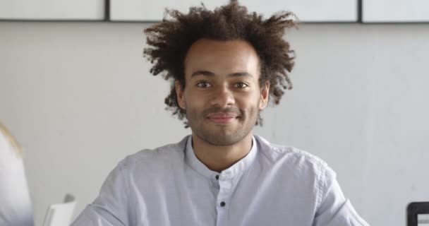 Portrait d'un étudiant africain heureux souriant dans un espace de coworking lumineux. Heureux d'avoir des connaissances. Un tir moyen. Mouvement lent . — Video