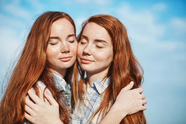 Duas irmãs gengibre abraçando um ao outro em um dia ensolarado brilhante compartilhando seu calor e emoções umas com as outras . — Fotografia de Stock