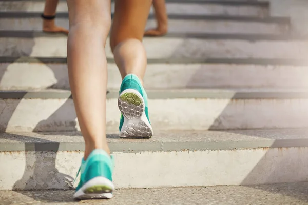 Primo piano di giovane donna gambe sportive che si preparano a correre di sopra sul suo allenamento urbano quotidiano. Stile di vita sano concetto. — Foto Stock