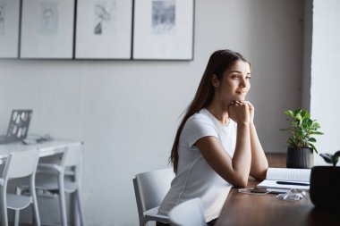 Genç Bayan parlak coworking oturan onun kariyer üzerine karar alan eğitim. Gülümseyen dışında arıyorsunuz.